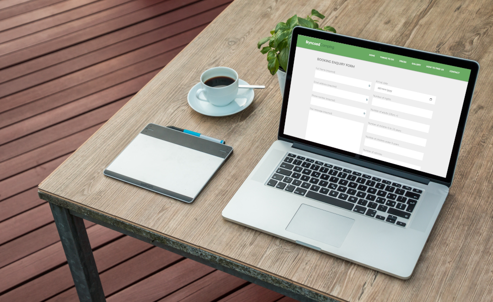 Efficient online booking system setup on a modern laptop in a Wales tech workspace.